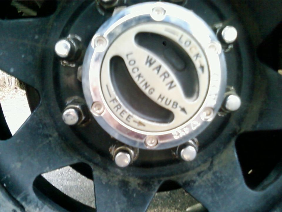 Chrome Warn locking hub with LOCK/FREE dial on a black wheel