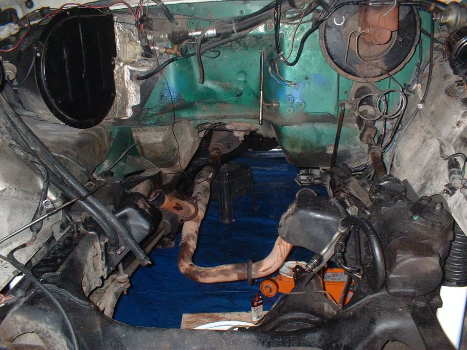 Engine bay and undercarriage view with exhaust pipes and steering components visible