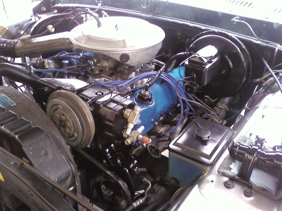 Engine bay of a 1978 Ford Bronco with a blue valve cover and chrome air cleaner