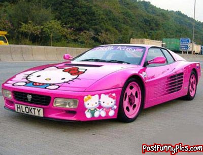 2000 Mercury Grand Marquis - A pink sports car adorned with Hello Kitty graphics is seen from a three-quarter front view.