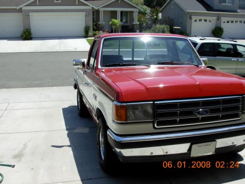 1988 Ford F-150 - A two-tone Ford F-150 pickup truck is parked in a suburban driveway.