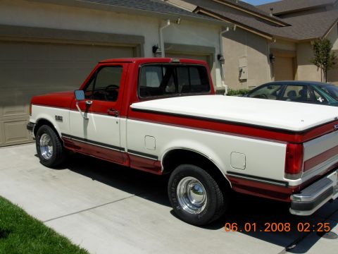 1988 Ford F-150 - This two-tone red and white 1988 Ford F-150 pickup truck is shown from a three-quarter front angle.