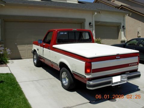 1988 Ford F-150 - Rear view of a two-tone red and white 1988 Ford F-150 pickup truck with a white bed cover.