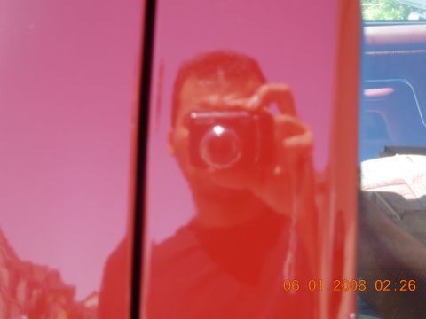 1988 Ford F-150 — Reflection of person holding camera in shiny red truck door