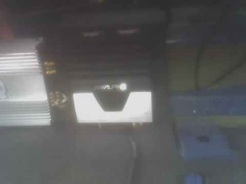 2001 Ford Crown Victoria - Close-up of an Alpine car audio amplifier, likely installed in a vehicle's trunk or under a seat.