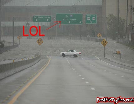 2000 Mercury Grand Marquis - A white 2000 Mercury Grand Marquis navigates a flooded road under highway signs.