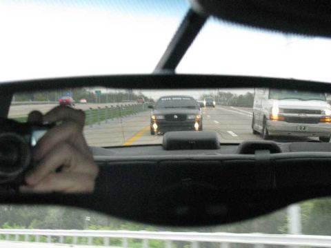 2003 Mercury Marauder - A black 2003 Mercury Marauder is seen driving on the highway, reflected in the rearview mirror.
