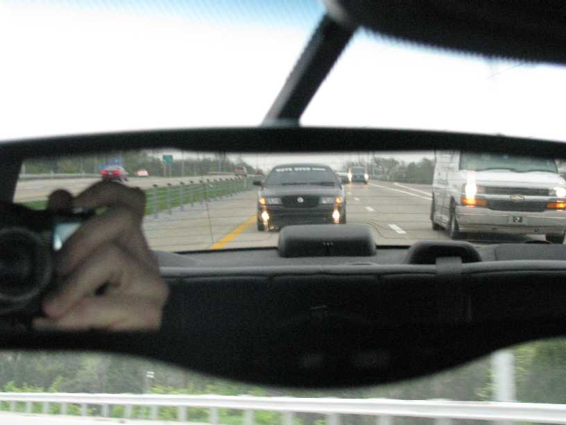 Black 2003 Mercury Marauder on highway, seen through rearview mirror