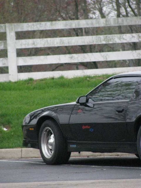 2003 Mercury Marauder - Side view of a black car parked near a white fence.