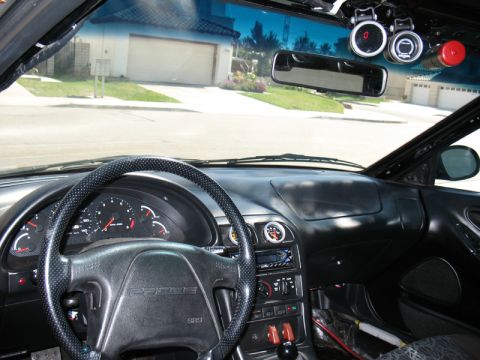 1995 Ford Probe - The interior of a car, a steering wheel with 'PROBE' visible and several aftermarket gauges mounted on the windshield.