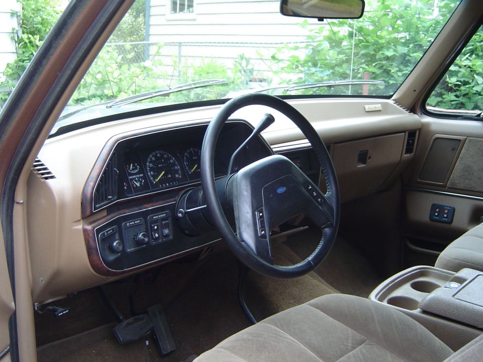 Tan interior of a 1992 Ford F-Series truck showing the dashboard, steering wheel, and seats