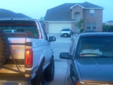 1992 Ford Bronco - A 1992 Ford Bronco is parked in front of a house, with another vehicle beside it.