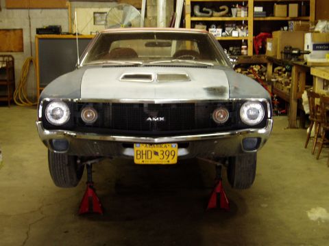 2000 Ford E350 - Front view of an AMC AMX in a garage, raised on jack stands.