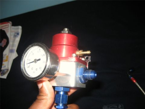 1993 Ford Probe - A fuel pressure regulator with an attached gauge is held in hand. The gauge indicates a pressure of 40 PSI.