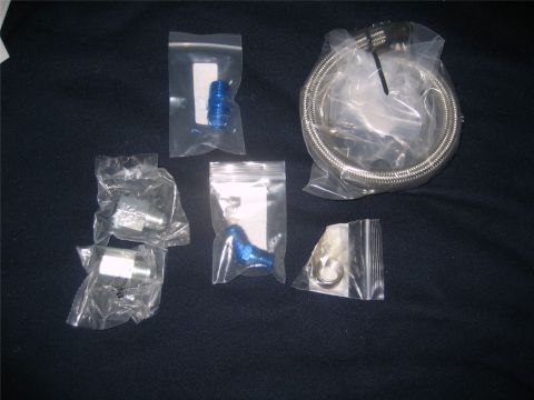 1993 Ford Probe - A collection of assorted automotive fittings and a braided hose are displayed on a dark, textured background.