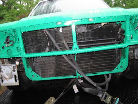 1991 Ford LTD Crown Victoria - The front end of a vehicle is shown with the radiator and condenser exposed, secured by straps.