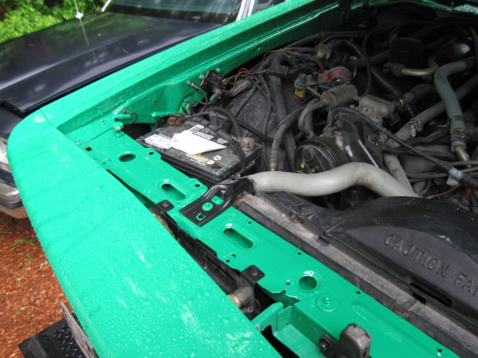 1991 Ford Crown Victoria LTD engine bay with green painted inner fender and battery