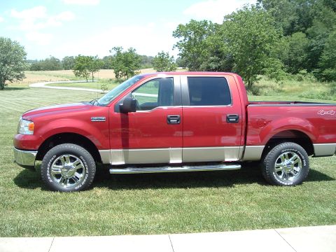 2008 Ford F-150 - Side view of a red pickup truck with a tan lower body and chrome accents.