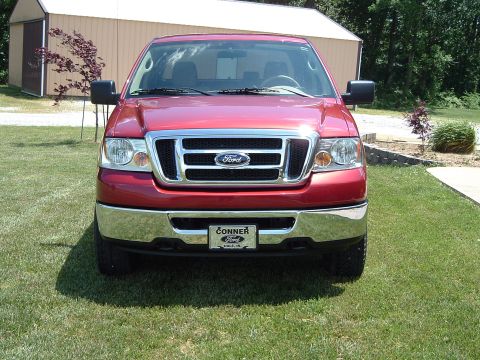 2008 Ford F-150 - This red Ford F-150 pickup truck is shown from the front, its distinctive grille and chrome bumper.