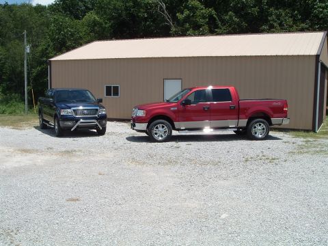 2008 Ford F-150 - Two Ford F-150 pickup trucks are parked on a gravel lot in front of a metal building.