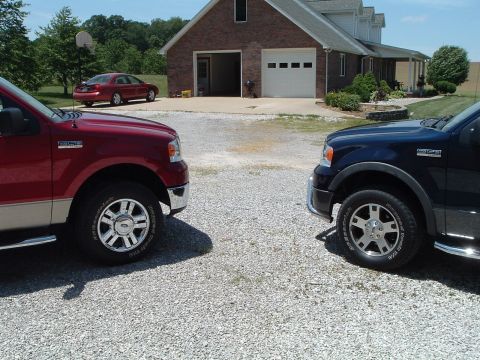 2008 Ford F-150 - Two 2008 Ford F-150 trucks are parked in front of a residential garage.