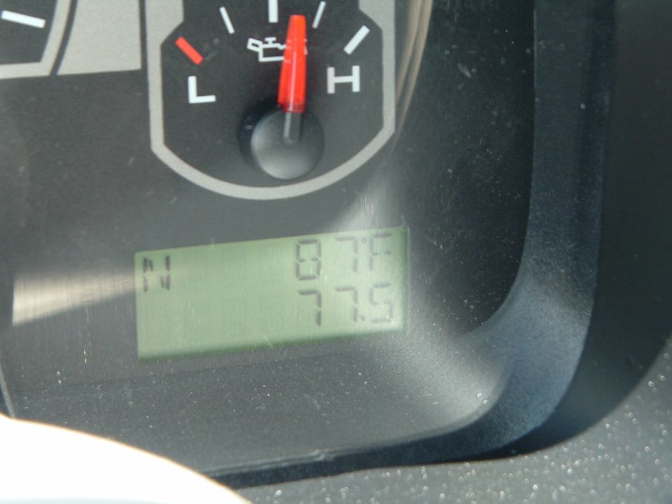 Truck oil-pressure gauge and green LCD odometer reading 775 miles in N