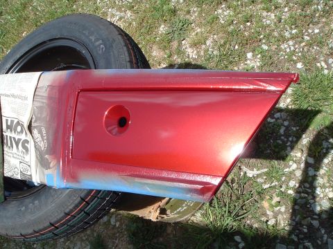 1999 Mercury Grand Marquis - A red car door is being worked on, with a tire and newspaper visible in the background.