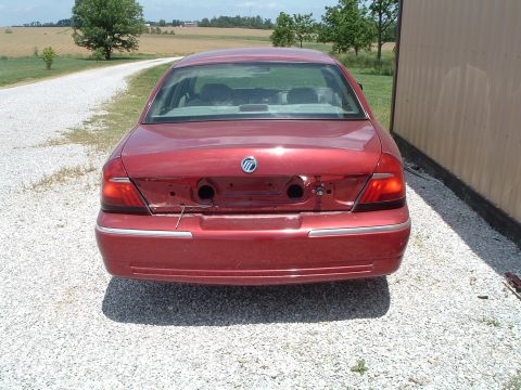 1999 Mercury Grand Marquis - The rear of a red sedan is shown, with its license plate area and bumper trim removed.
