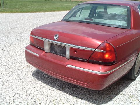 1999 Mercury Grand Marquis - Rear view of a red 1999 Mercury Grand Marquis sedan, showing its taillights and chrome accents.
