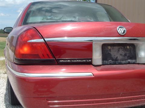 1999 Mercury Grand Marquis - The rear of a red Mercury Grand Marquis LS is shown, chrome accents and a license plate holder.