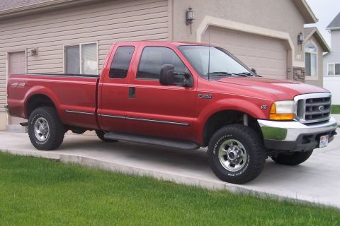 1995 Ford Bronco - This red Ford F-250 Super Duty pickup truck has a chrome grille and bumper, and appears to be from the late 1990s.