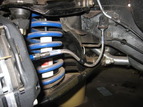 1978 Ford Mustang II - Close-up of a blue coilover shock absorber assembly on a vehicle's front suspension system.