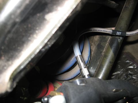 1978 Ford Mustang II - A close-up view of automotive brake lines and suspension parts, with a visible DOT tag on one of the lines.