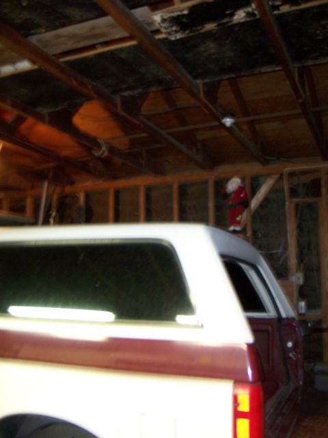 1991 Ford Bronco - The rear of a two-tone Ford Bronco is parked inside a garage with exposed wooden beams overhead.