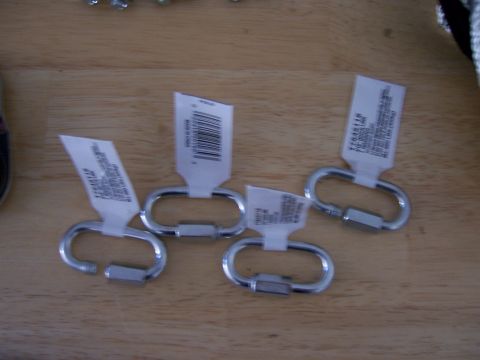 1991 Ford Bronco - Four carabiner clips with product tags are laid out on a wooden table.