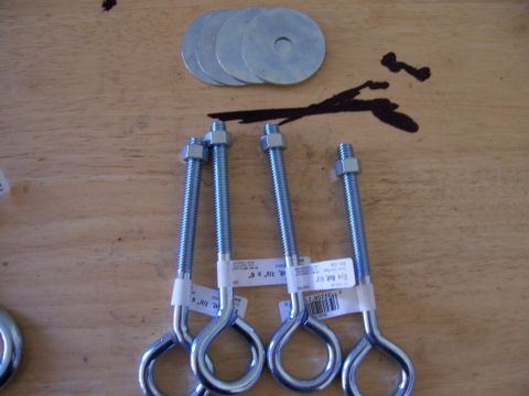 1991 Ford Bronco - Hardware components including eye bolts and washers are laid out on a wooden surface.