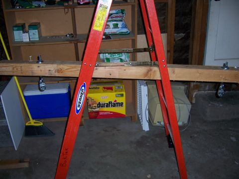 1991 Ford Bronco - A collection of items are stored in a garage, including a ladder, cooler, and firewood.