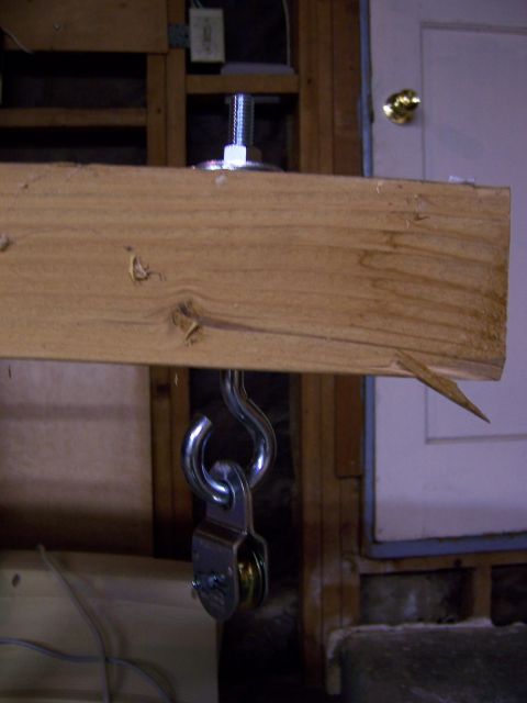1991 Ford Bronco - A pulley system is mounted to a wooden beam, with a metal hook and wheel visible.