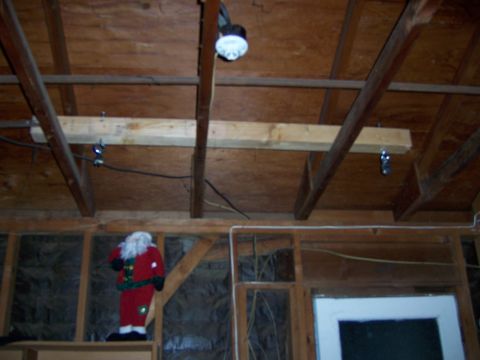 1991 Ford Bronco - A Santa Claus decoration is visible in a garage setting, surrounded by wooden beams and exposed insulation.