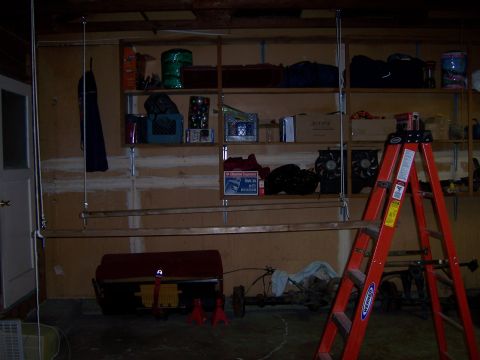 1991 Ford Bronco - Garage storage area with shelves, tools, and vehicle parts visible on the floor.