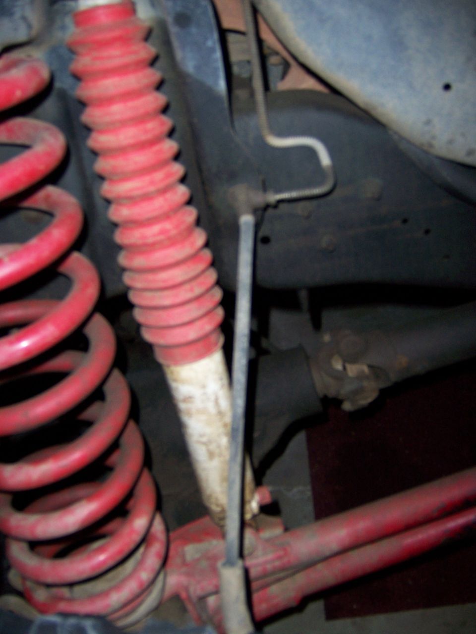 Red coil springs and red-booted shock absorber, part of a high-lift suspension