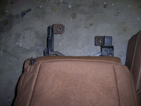 1991 Ford Bronco - Car seat mounting hardware shown in detail against a concrete floor.