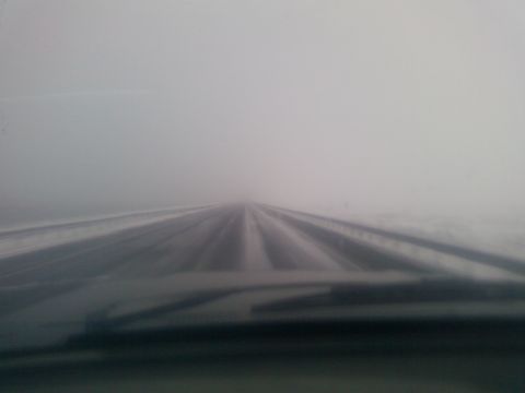 1988 Ford Bronco - Driving through heavy fog and snow on a road, visibility is extremely limited.