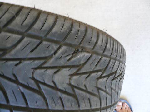 1996 Ford Probe - A close-up of a tire tread shows a puncture mark.