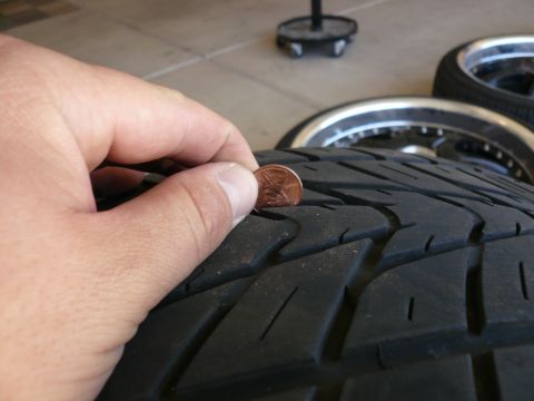 1996 Ford Probe - A penny is used to measure the tread depth of a tire, indicating wear.