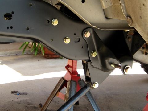 1996 Ford Bronco - The vehicle's frame and suspension parts are visible, supported by jack stands during maintenance.