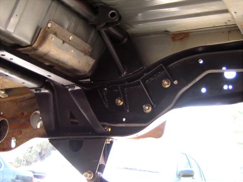 1996 Ford Bronco - Close-up view of aftermarket rear suspension components installed on a vehicle frame.