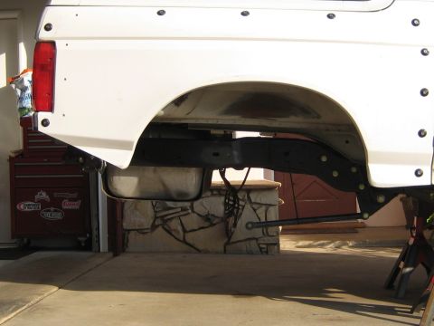 1996 Ford Bronco - The rear suspension of a white 1996 Ford Bronco is shown, with a fuel tank suspended beneath the frame.