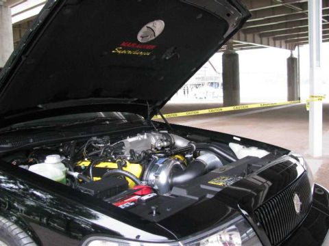 2003 Mercury Marauder - The engine bay of a black 2003 Mercury Marauder is shown, with the hood open revealing the engine and "Marauder Supercharged" text on the u…