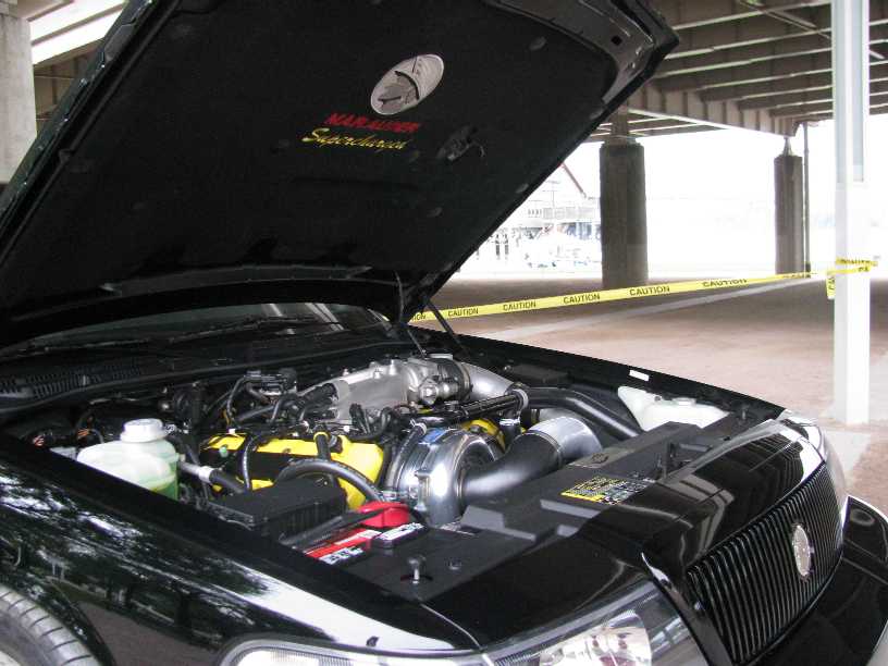 Black 2003 Mercury Marauder engine bay with "Marauder Supercharged" text on hood liner